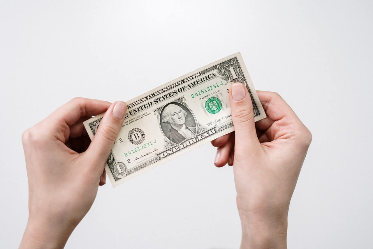 two-hands-holding-one-dollar-bill